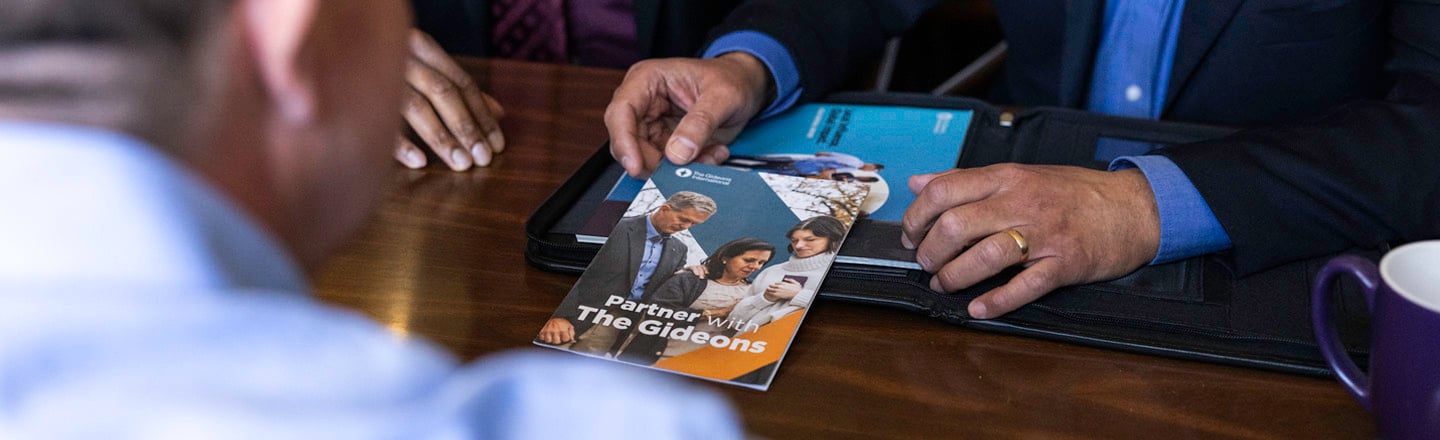 Gideons handing a church leader resources