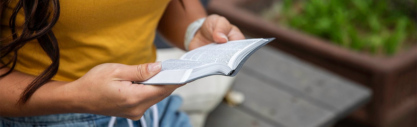 Woman reading a bible outside