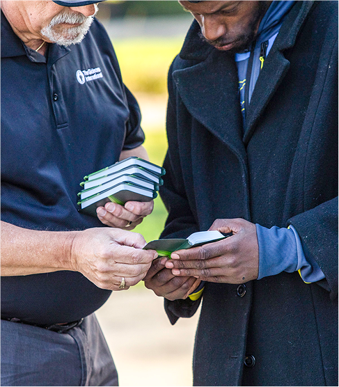 Man showing a bible to another man