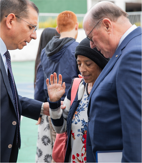 Men praying with woman outside