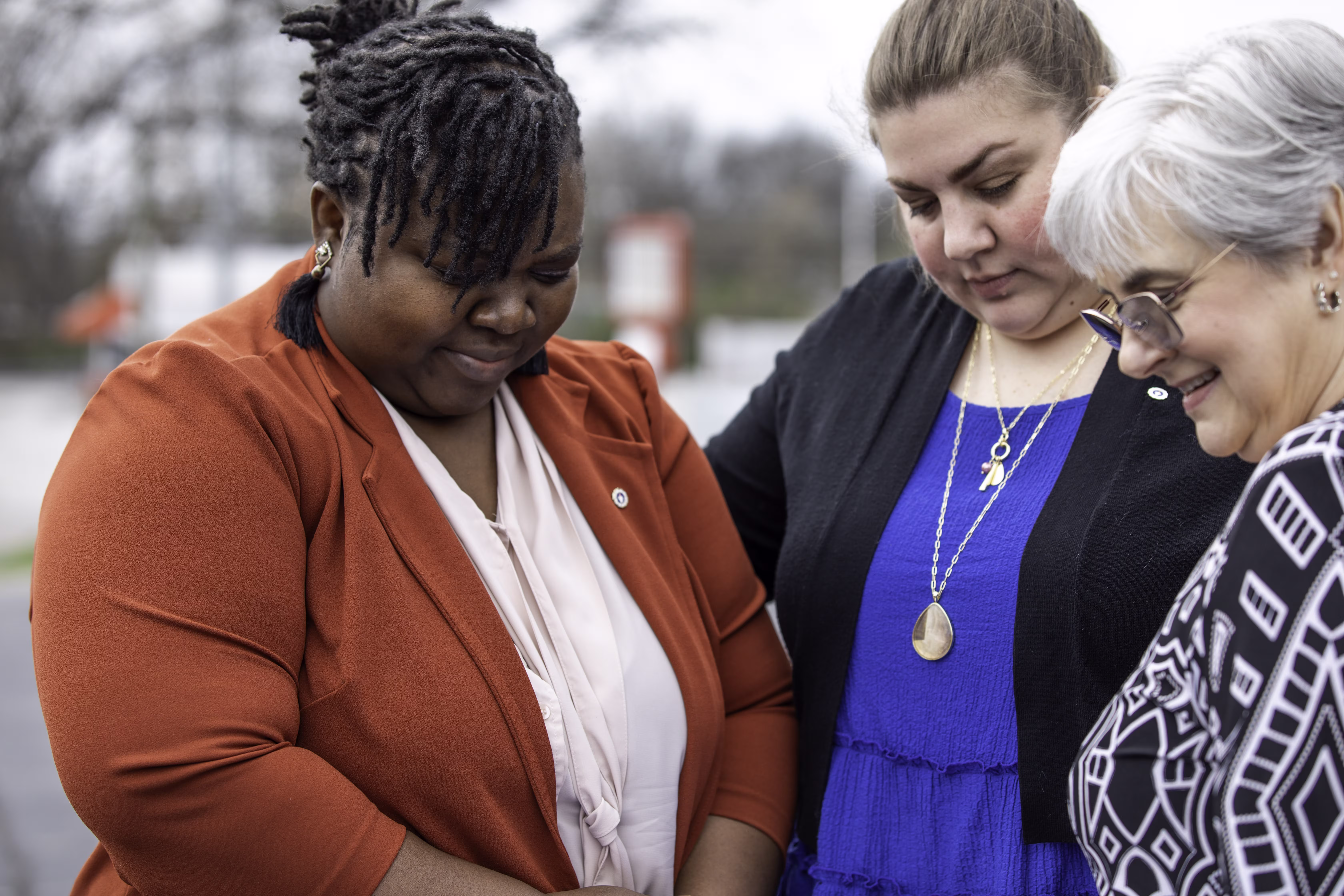Women gathered praying together outside