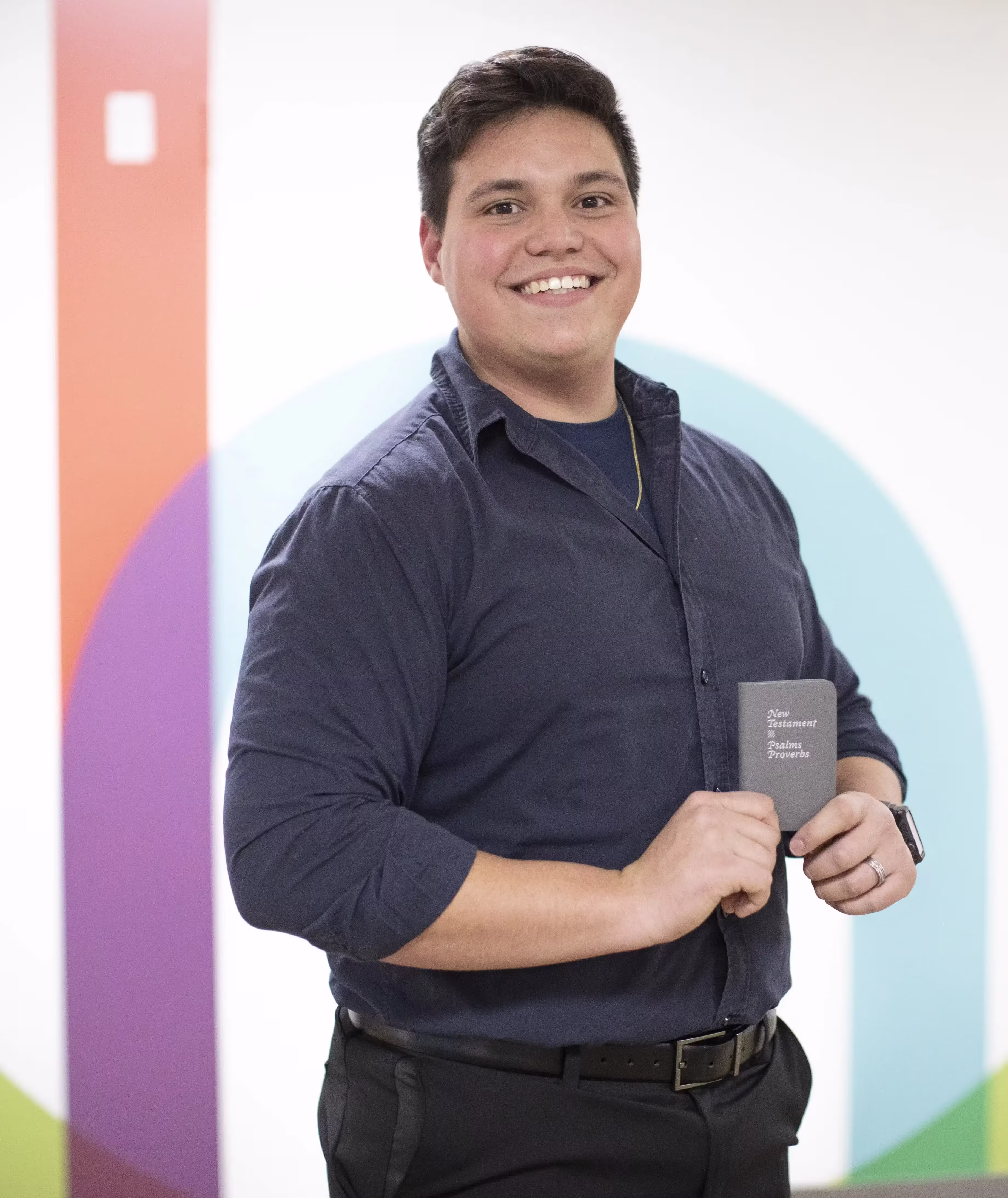 Man standing with bible in hand while smiling