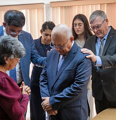 Members praying over a Pastor in Mexico City