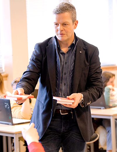 Geir handing testaments to students.